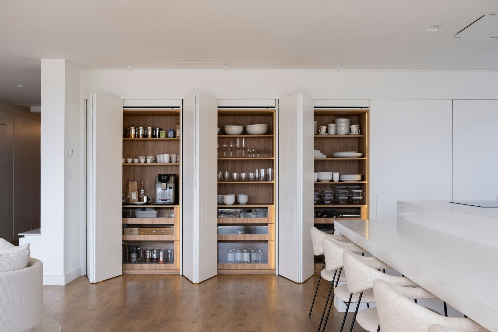 Três armários embutidos com louças e outros itens em uma cozinha.